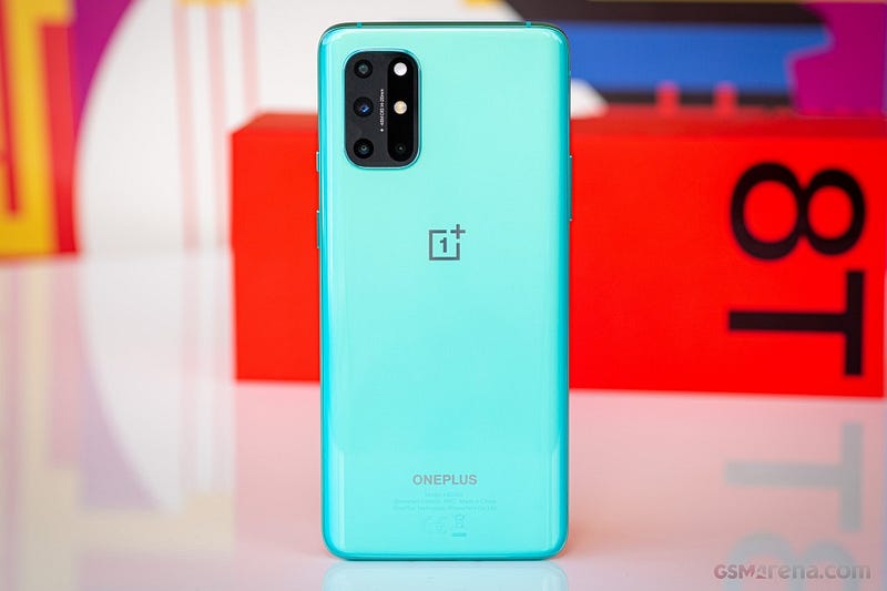 Image of the Oneplus 8T with the packaging in the background. Image from https://www.gsmarena.com/oneplus_8t-pictures-10420.php